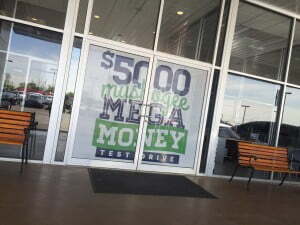 Window with perforated vinyl with the phrase $5000 Muskogee Mega Money