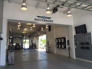 A seemingly empty bay with an emblem above a doorway that says "Auffenberg"